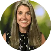 Smiling Green Mountain Treatment Center staff headshot with blurred green background