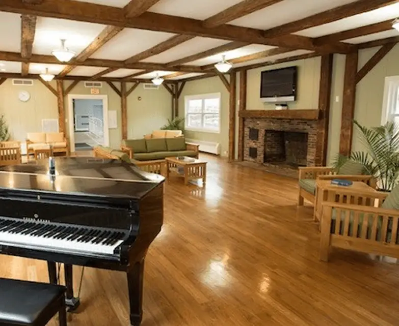 Rally Point Recovery communal lounge with grand piano and fireplace