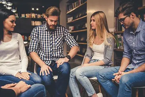 two men and two women meet in the library of a benzo addiction rehab center