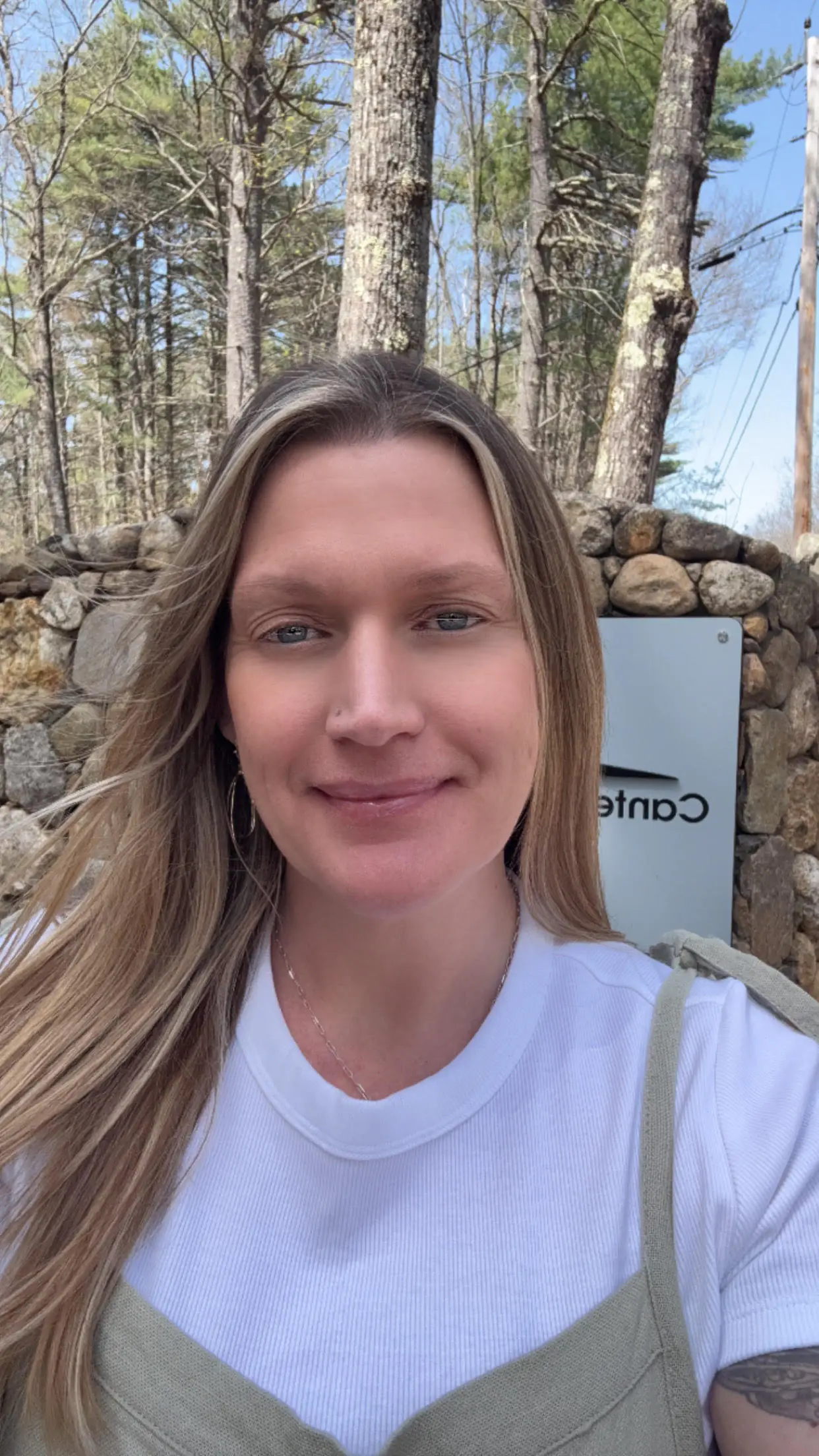 Clinician smiling outdoors by Canterbury Inpatient Care sign